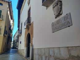 Fachada exterior del Museu de Mallorca con escudo y placa identificativa en calle estrecha