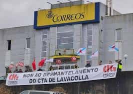 Fachada del Centro de Tratamiento Automatizado de Correos en Lavacolla con pancartas de protesta