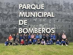 Grupo de visitantes posando frente al letrero del Parque Municipal de Bomberos de Santander