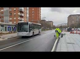 Vista de la calle Jacinto Benavente tras las obras del BEI, con trabajadores en el pavimento y un autobús en movimiento