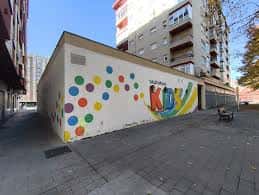 Fachada de un local comercial en la calle Jacinto Benavente con mural colorido y señalización de alquiler