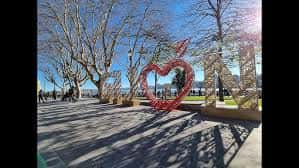 Escultura del corazón rojo en el Solarón con árboles y personas paseando