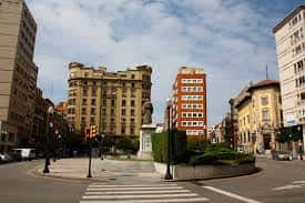 Plaza del Seis de Agosto con estatua central y edificios circundantes