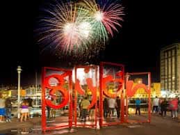 Plaza 3 de abril en Gijón con fuegos artificiales y estructura de letras rojas