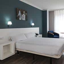 Habitación doble moderna con decoración minimalista y pared azul oscuro