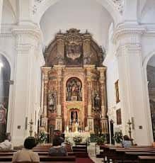 Interior de la Iglesia de San Bartolomé con el retablo mayor y fieles en las bancas
