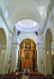 Vista interior de la nave central de la Iglesia de San Bartolomé con cúpula y retablo dorado