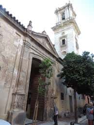 Exterior de la Iglesia de San Bartolomé con torre campanario y fachada de piedra