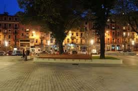 Plaza Corazón de María al atardecer con iluminación cálida y bancos en primer plano