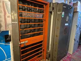 Puerta de caja fuerte naranja con rejas en el interior