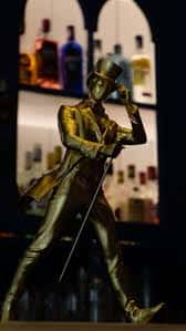 Estatua dorada de un caballero con sombrero en el interior del bar