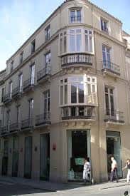 Fachada exterior de la Librería Proteo en Málaga, mostrando su arquitectura clásica con balcones y escaparates