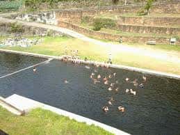 Vista aérea de la playa fluvial de Os Peares con personas nadando y disfrutando del agua