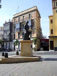 Vista frontal del monumento en plaza urbana con arquitectura sevillana