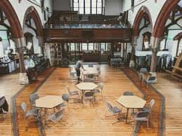 Interior del salón principal de One Church Brighton con mesas y sillas dispuestas para eventos
