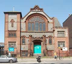 Fachada exterior de One Church Brighton en Gloucester Place, Brighton, con puerta verde y arquitectura victoriana