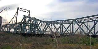Vista lateral del Puente de Alfonso XIII mostrando su estructura metálica y el río Guadalquivir