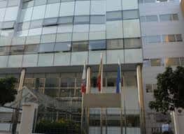 Fachada principal del edificio con banderas y entrada accesible