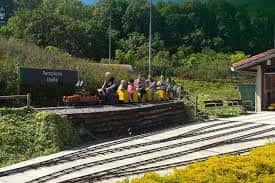 Tren turístico en el Parque del Tren de Trinitarios con pasajeros disfrutando del recorrido