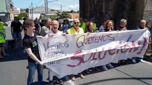 Grupo de vecinos manifestándose con pancartas en la calle, relacionado con la asociación de Monte Martelo