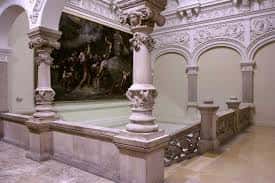 Interior del museo con columnas ornamentadas y pintura mural