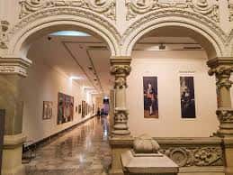 Galería interior del museo con arcos, columnas y obras expuestas