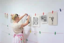 Participante colgando ilustraciones en un taller de fanzine