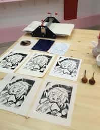 Mesa de trabajo con estampados de fanzine y herramientas de impresión
