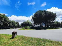 Vista del entorno exterior con zona ajardinada y acceso a la escuela