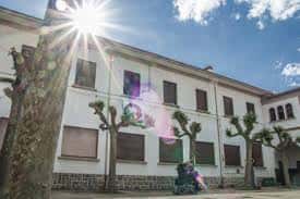 Vista exterior del Centro Comunitario Salesianas con fachada blanca y árboles en primer plano