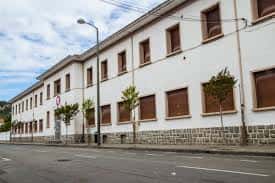 Fachada lateral del edificio del Centro Comunitario Salesianas bajo cielo parcialmente nublado