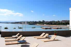 Terraza con tumbonas y piscina infinita con vistas al mar