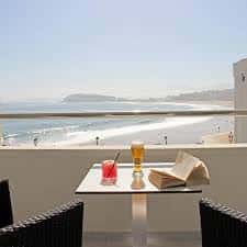 Terraza con mesa y bebidas frente a la playa y el mar
