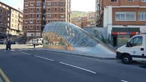 Estructura moderna de cristal en la Plaza Iturriondo con tráfico y edificios al fondo