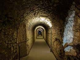 Pasaje subterráneo con bóvedas de piedra iluminadas dentro del museo