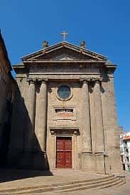 Fachada principal de la Capilla de Ánimas con columnas y cruz en la parte superior