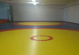 Sala de entrenamiento con tatami amarillo y rojo para deportes de combate