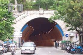 Vista frontal del túnel con vehículos y motocicletas estacionados a los lados