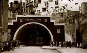 Entrada del túnel durante una celebración con banderas colgantes y multitud reunida