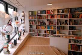 Interior de la librería con estanterías llenas de libros y zona de lectura