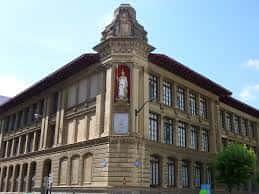 Fachada principal del Instituto Miguel de Unamuno con torre y escudo
