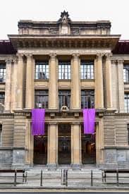 Fachada frontal con banderines púrpuras colgando de las columnas