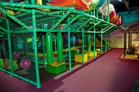 Estructura de parque infantil interior con redes y elementos coloridos