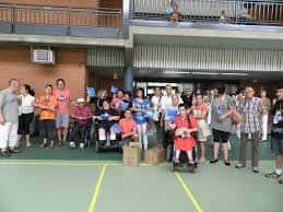 Reunión de personas con discapacidad y acompañantes en el patio deportivo del centro