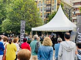 Evento musical al aire libre en el Paseo de Begoña con público y escenario bajo carpa blanca