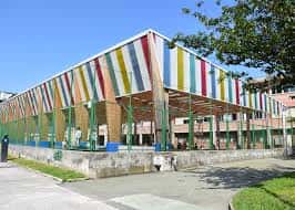 Fachada lateral del edificio con estructura de colores vivos y diseño contemporáneo