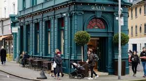 Fachada exterior de GAIL's Bakery Hove con arquitectura verde y clientes en la acera
