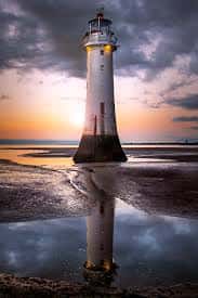 Faro de New Brighton al atardecer con reflejo en el agua