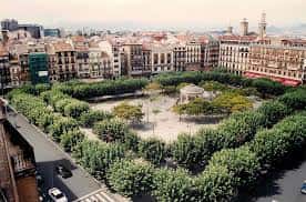 Vista aérea de la Plaza del Castillo con su jardín central y kiosco, mostrando la estructura urbana de Pamplona
