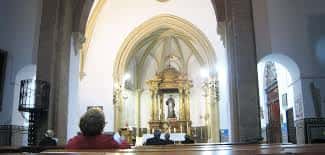 Vista del altar mayor desde el interior de la iglesia con detalles arquitectónicos góticos